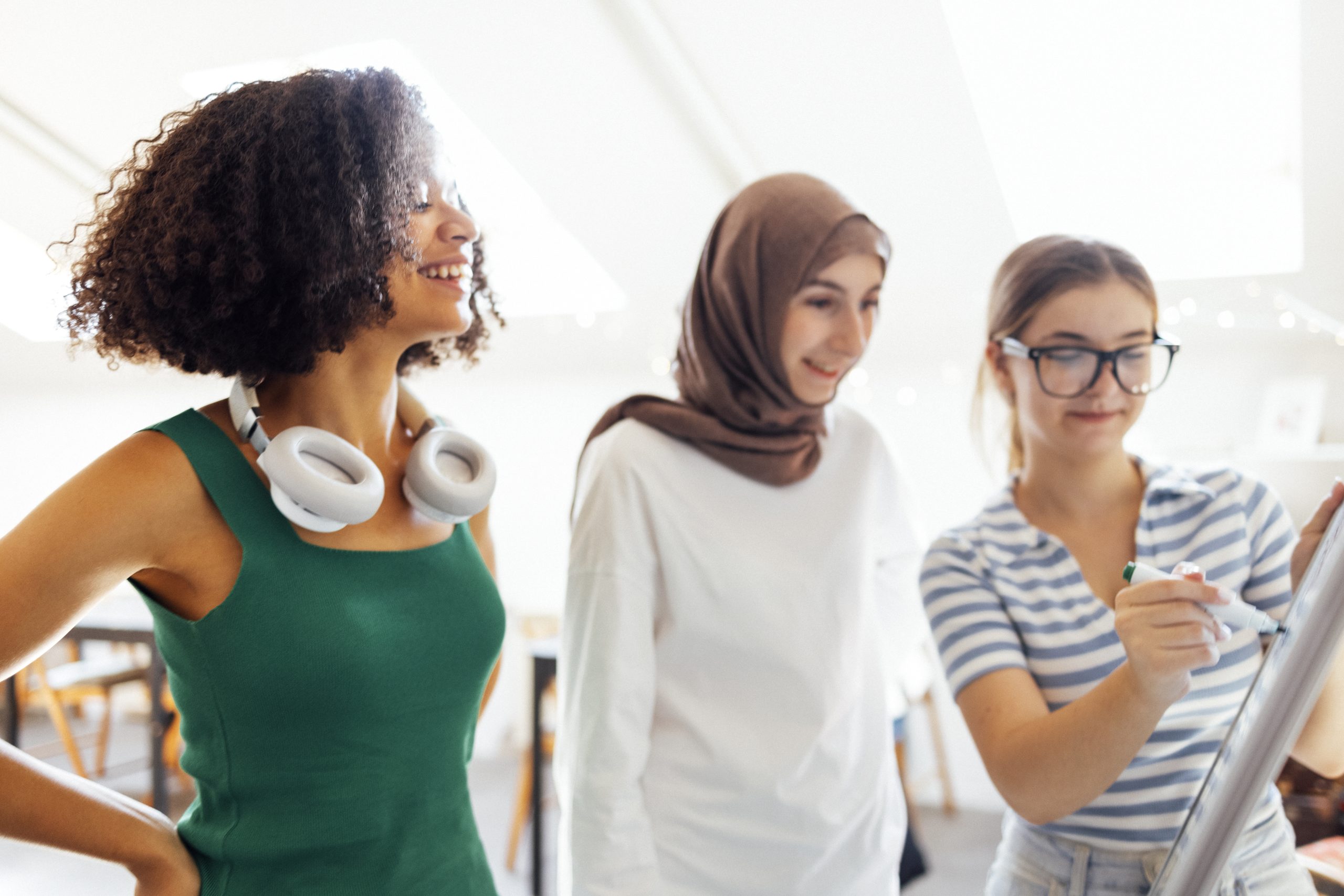 Brainstorming of three teenagers. Teens of different nationalities and religions solve problems together.